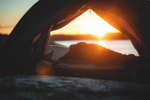 A person camping in a tent in the Scandinavian outdoors